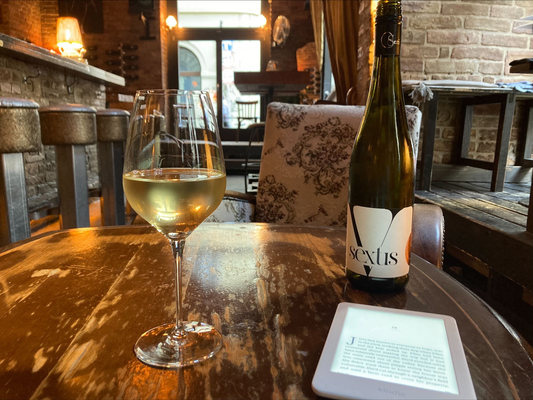 Sextis (rajnai rizling) hvidvin, et glas med hvidvin og en kindle på en vinbar i Budapest, Ungarn
